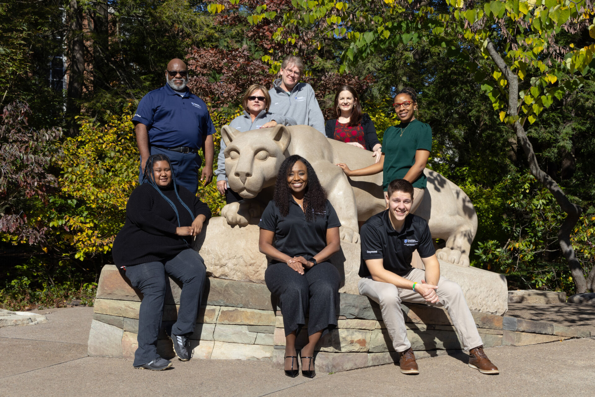Staff of the Office of Graduate Educational Equity Programs sitting by the Lion Shrine.