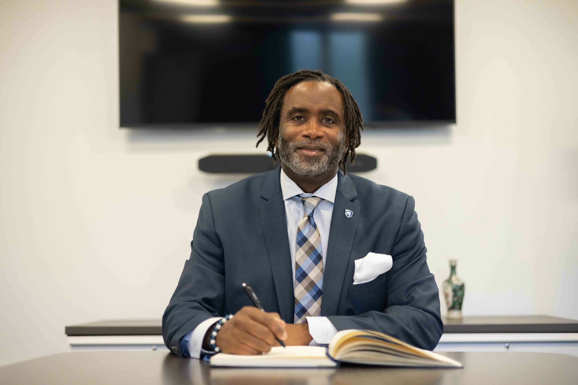 Vice Provost for Graduate Education and Dean of the Graduate School, Levon Esters, writes in a notebook in his office