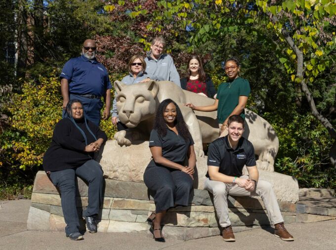 Staff members from the Office of Educational Equity Programs poses at the Nittany Lion Shrine