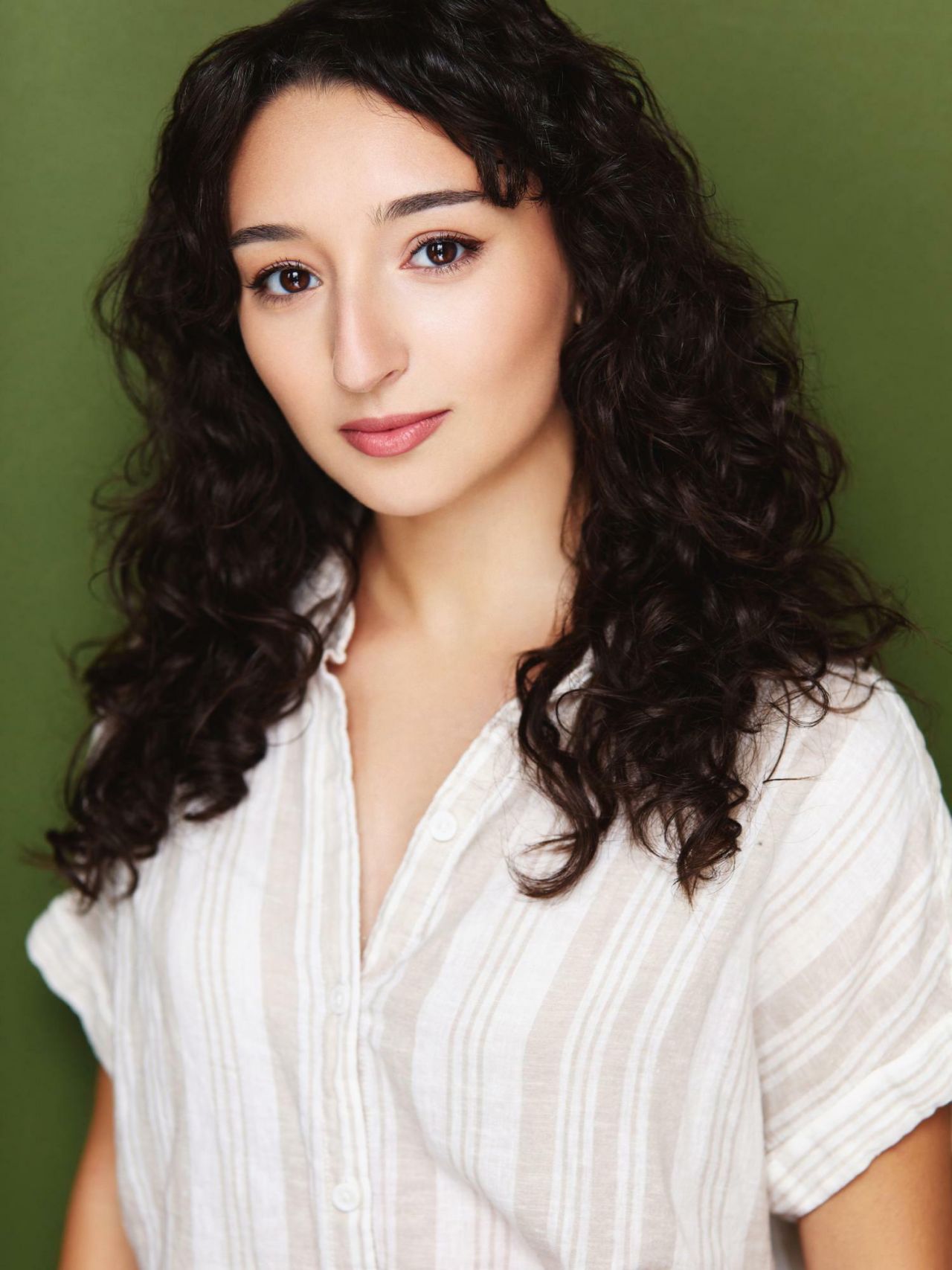 Head shot of a young woman with dark, wavy hair.